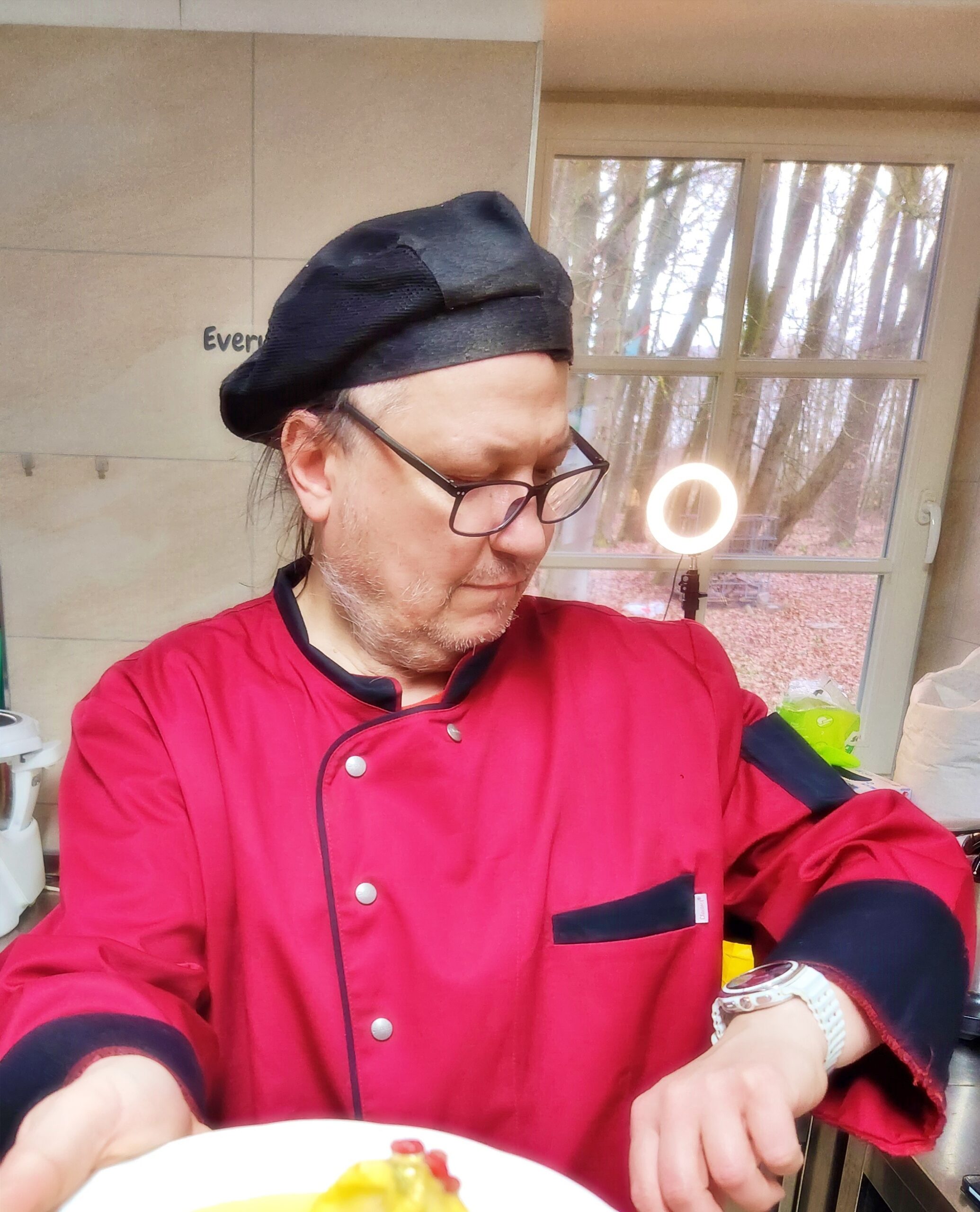 Piotr Krupa — Head Chef Rude Kitchen, w czerwonej kucharskiej bluzie i czarnym berecie szefa kuchni