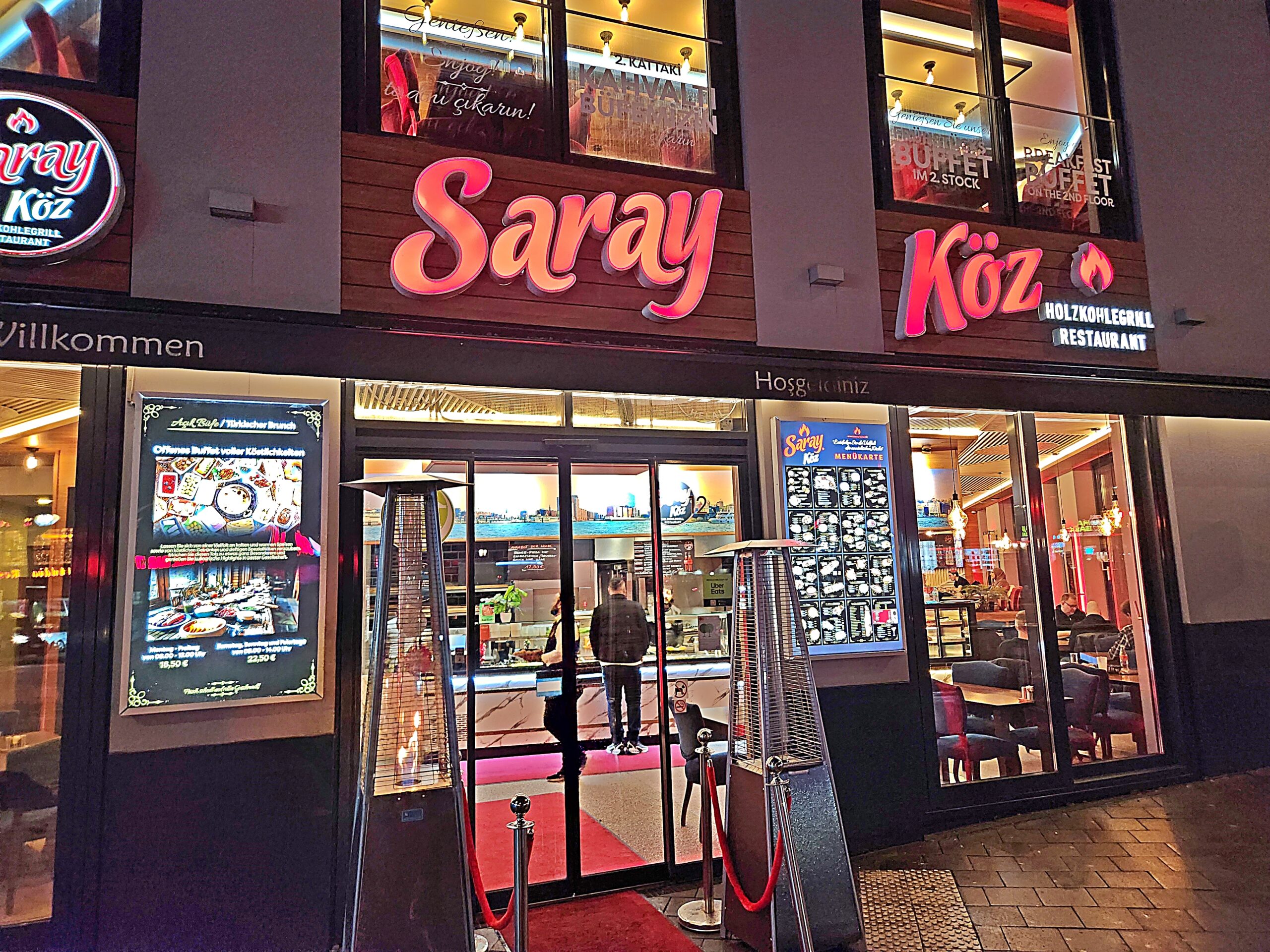 Neonowy szyld Saray Köz nad wejściem do tureckiej knajpy na St. Georg w Hamburgu, wieczorem